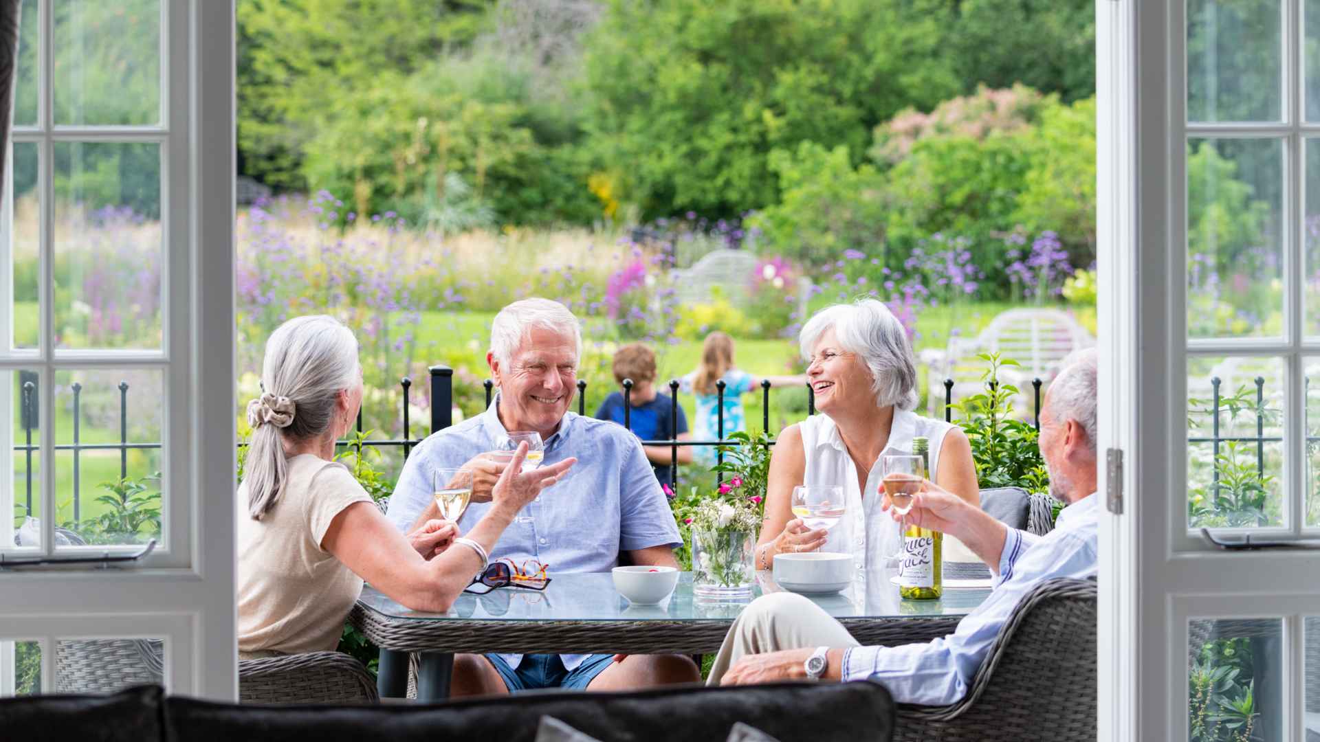 Four over 55's enjoying a drink on a terrace.