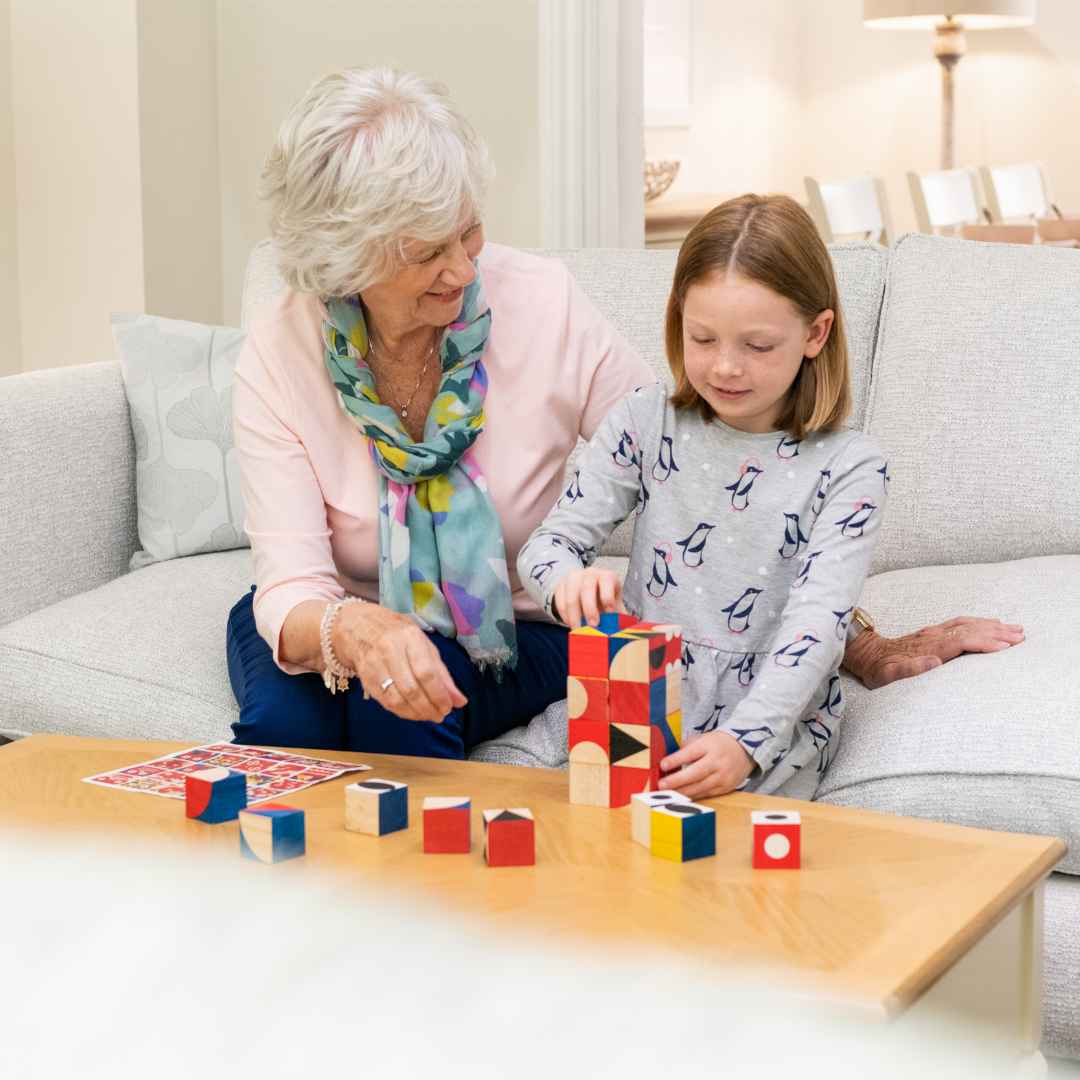 A grandmother and her granddaughter playing with blocks