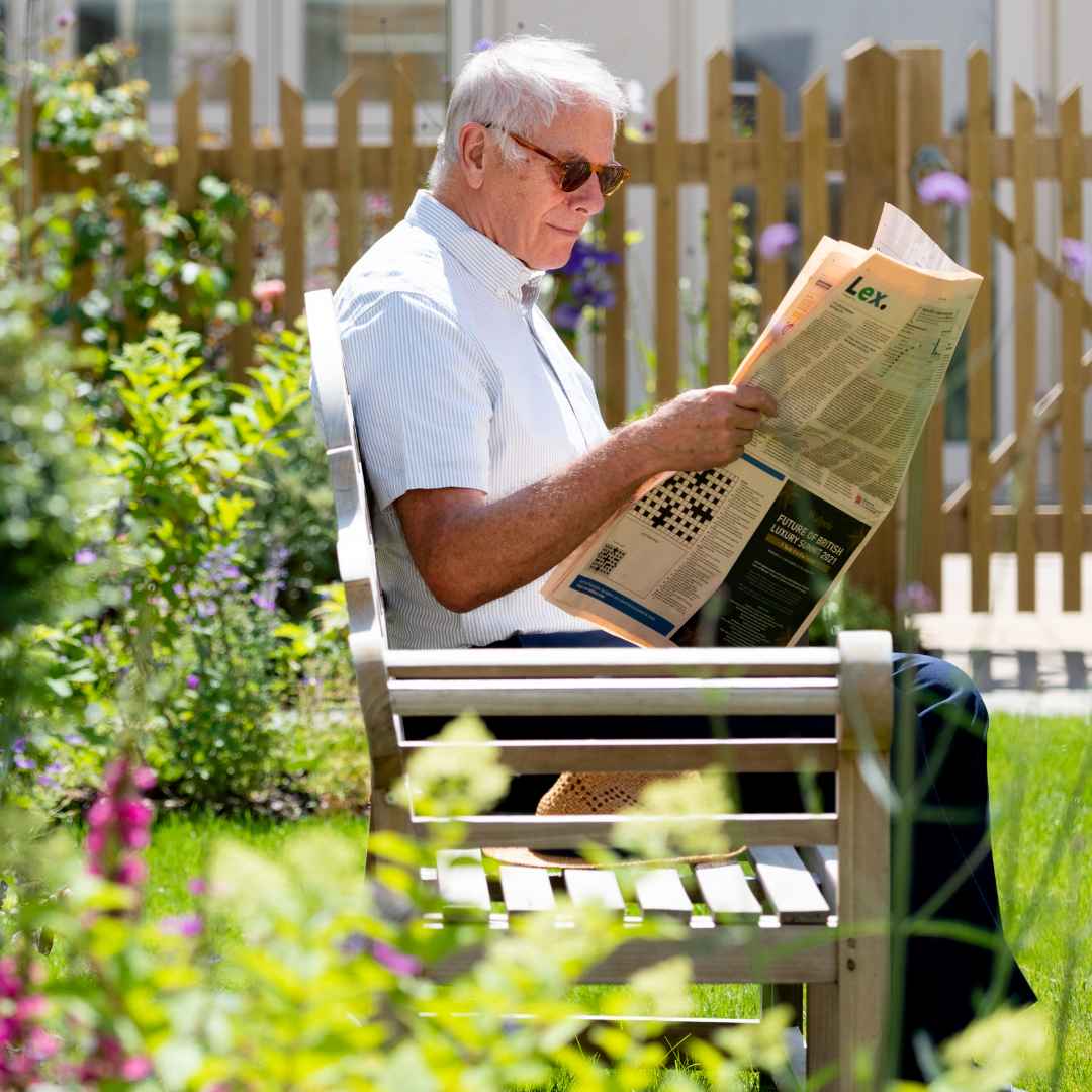 A man reading a newspaper in the garden