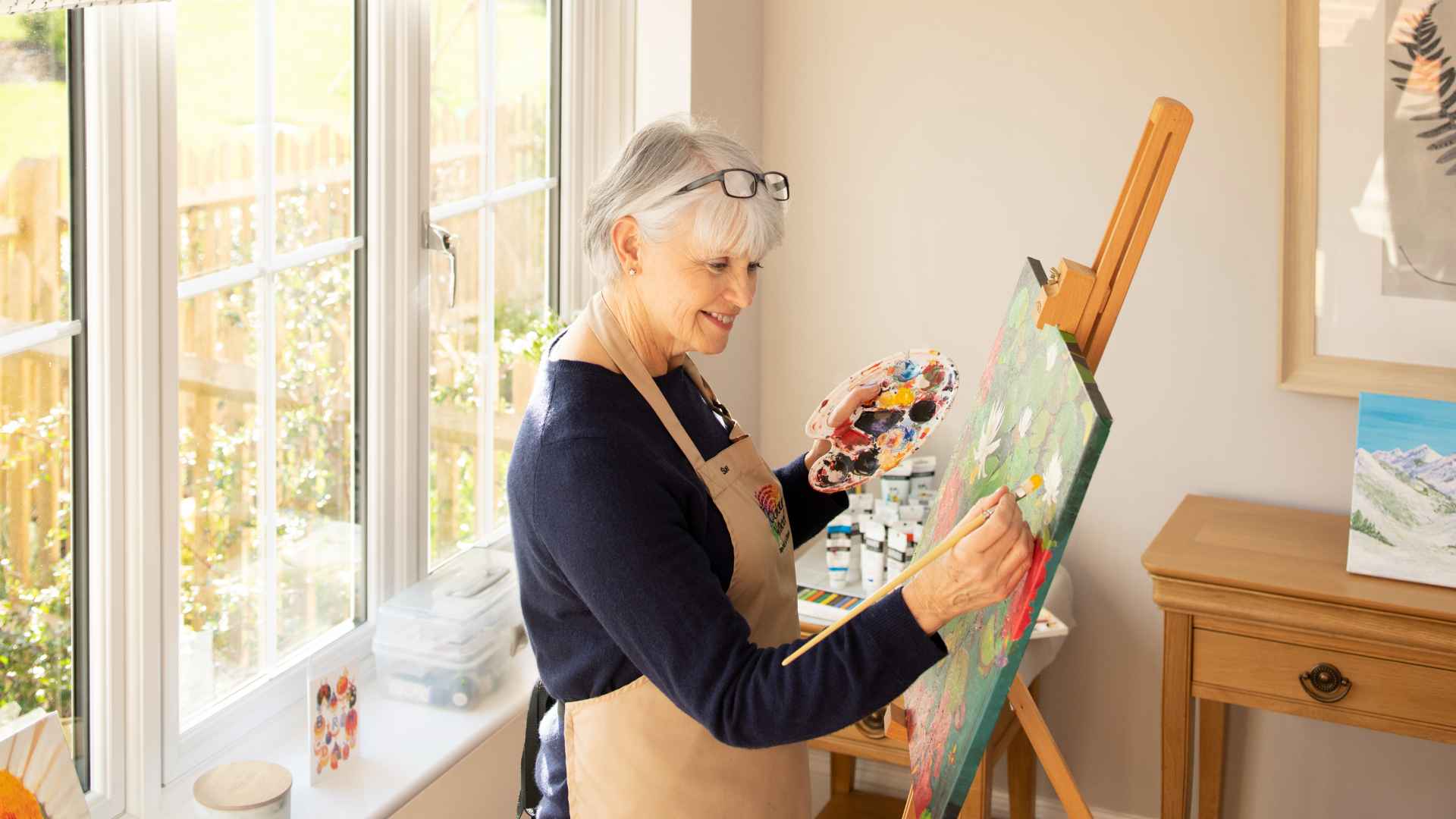 A lady painting a canvas