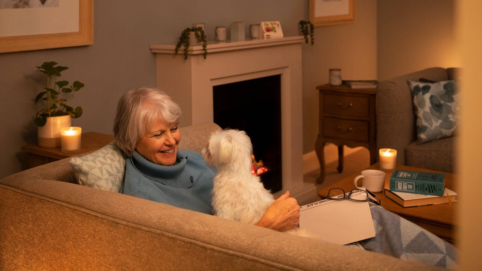 a lady in a warm living room with her dog