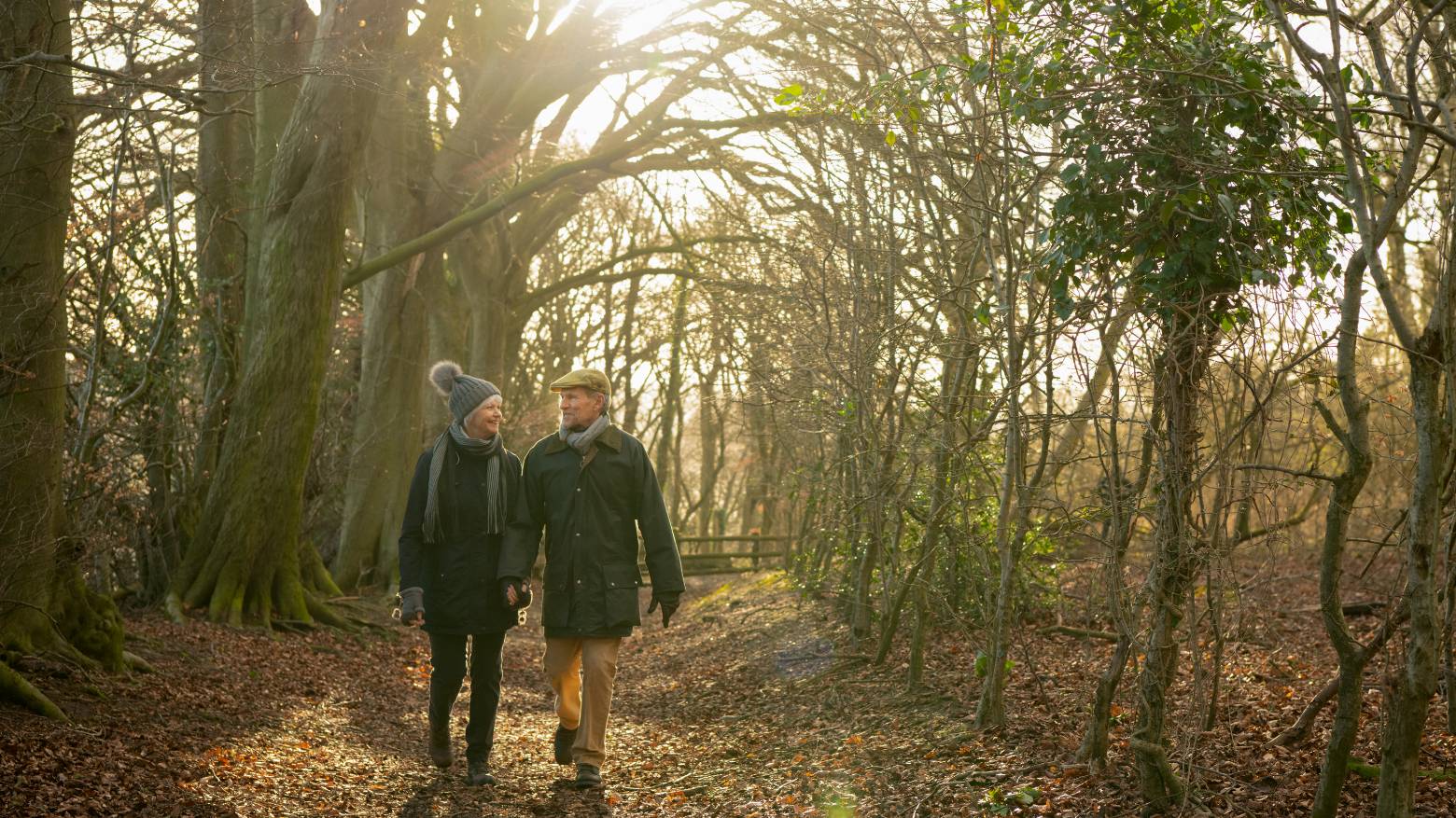 A couple walking through a forest in the winter