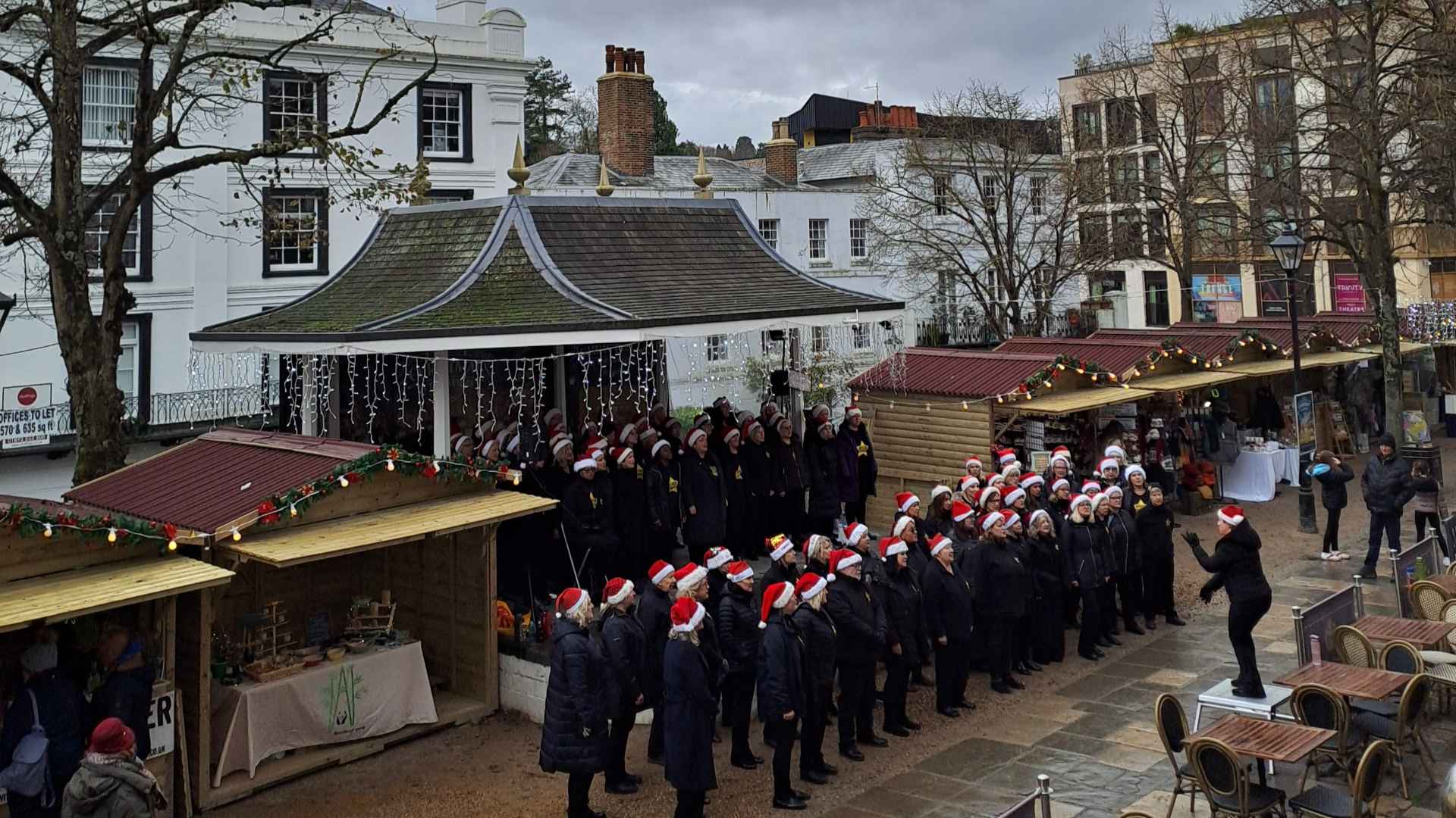 Carol singers wearing santa hats at the Pantiles Christmas Market in Tunbridge Wells