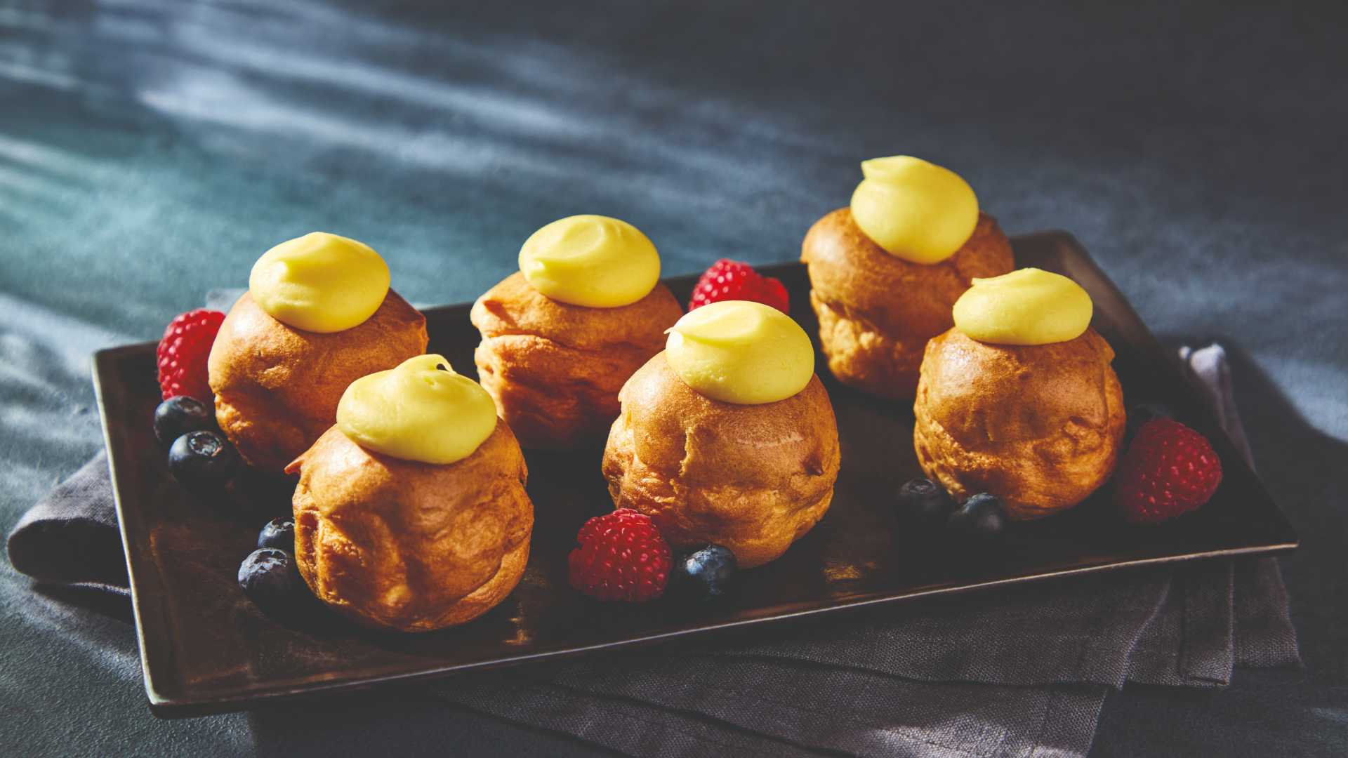 Choux pastries filled with stabilised cream, topped with lemon flavoured fondant.