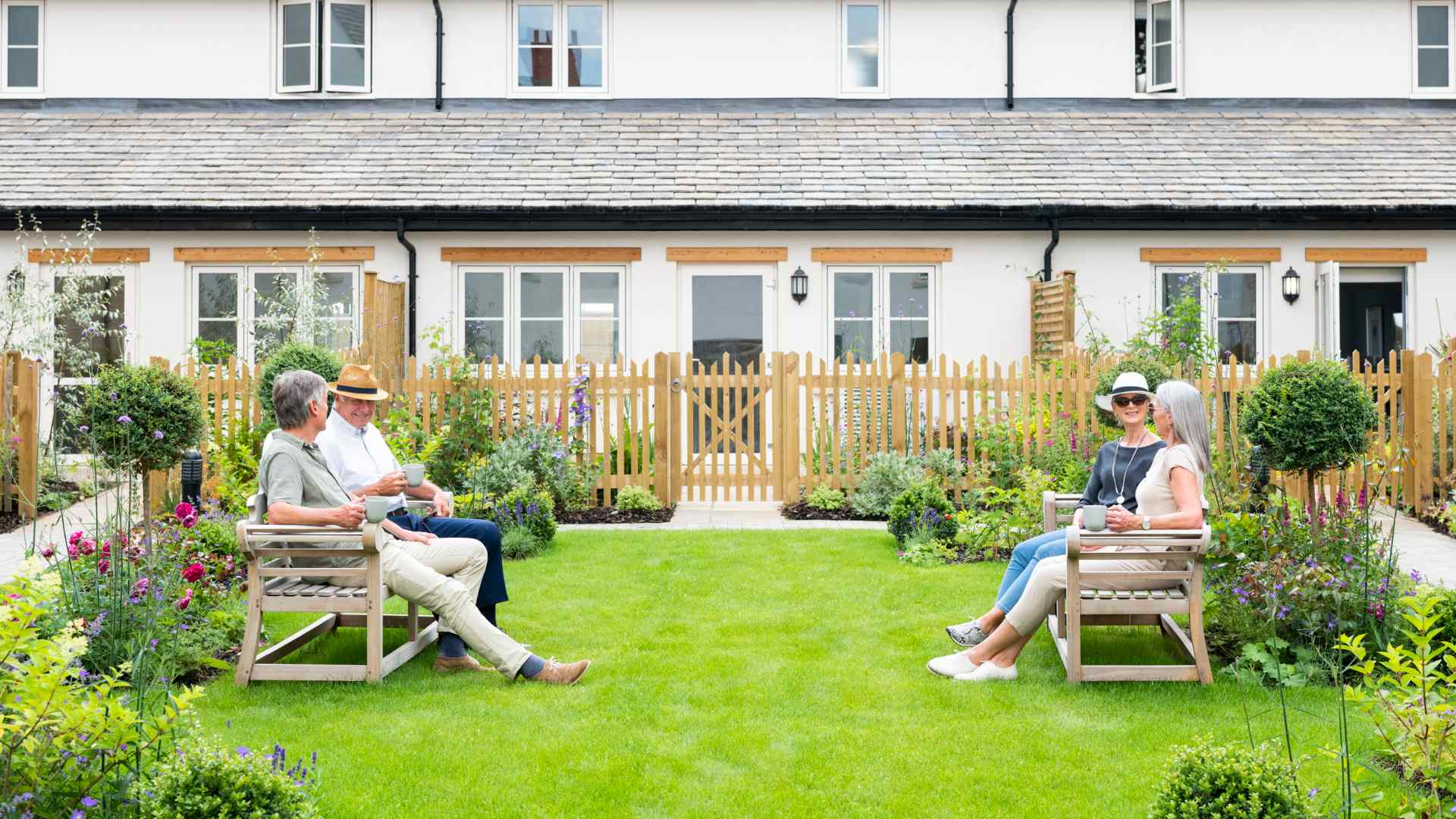 Four people sat in communal gardens