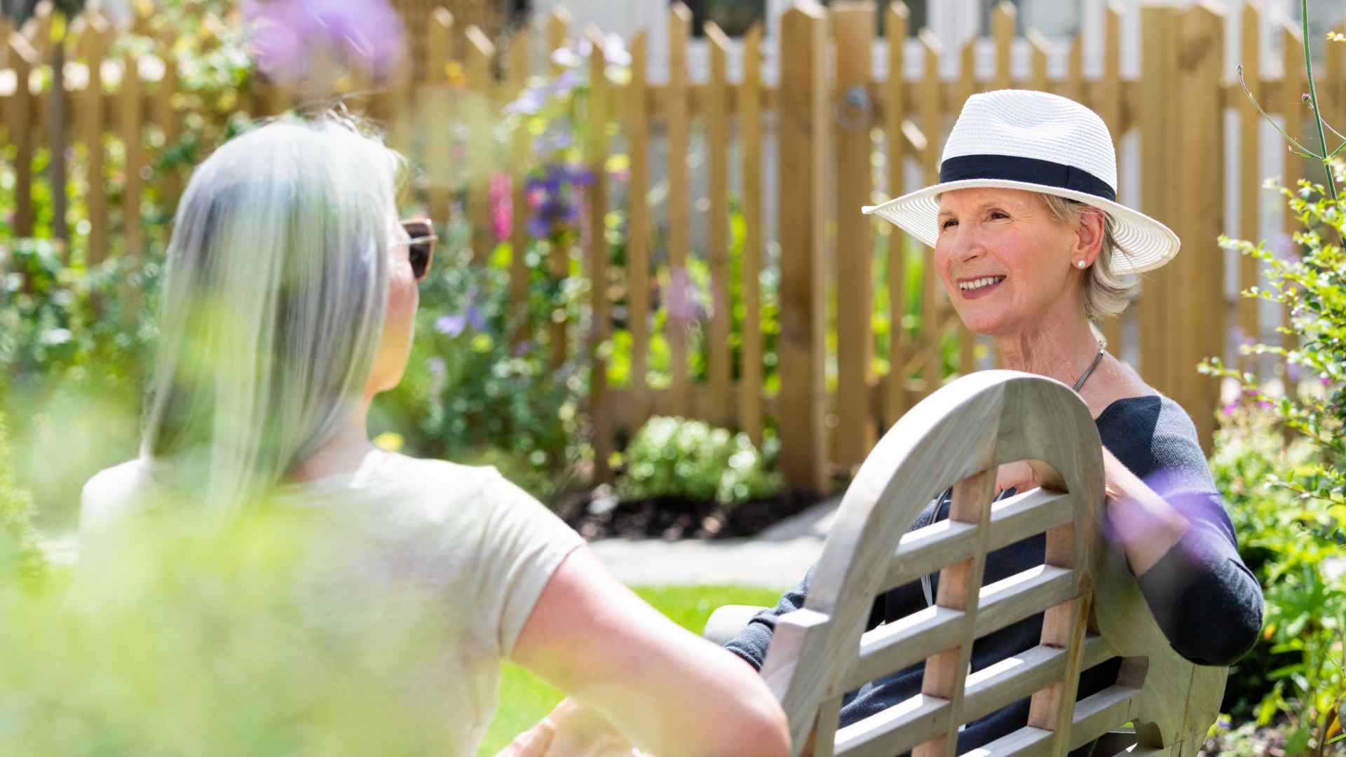 Two women speaking on a bench