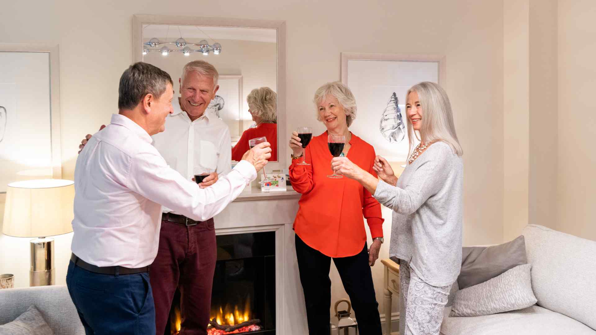 People raising a glass of red wine in a living room