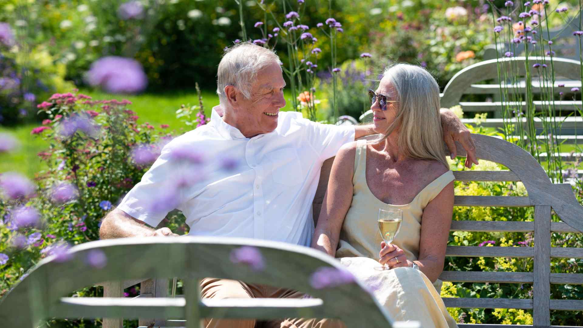 A man and a woman sitting on a bench in the garden.