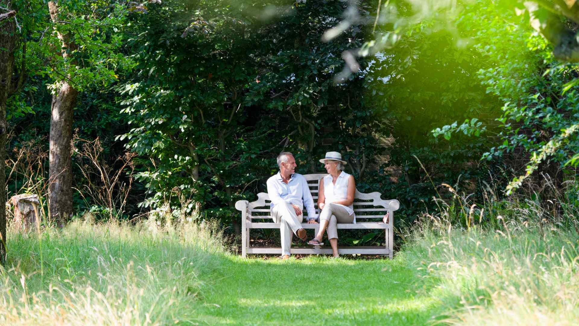 A couple sat on a bench in a communal garden