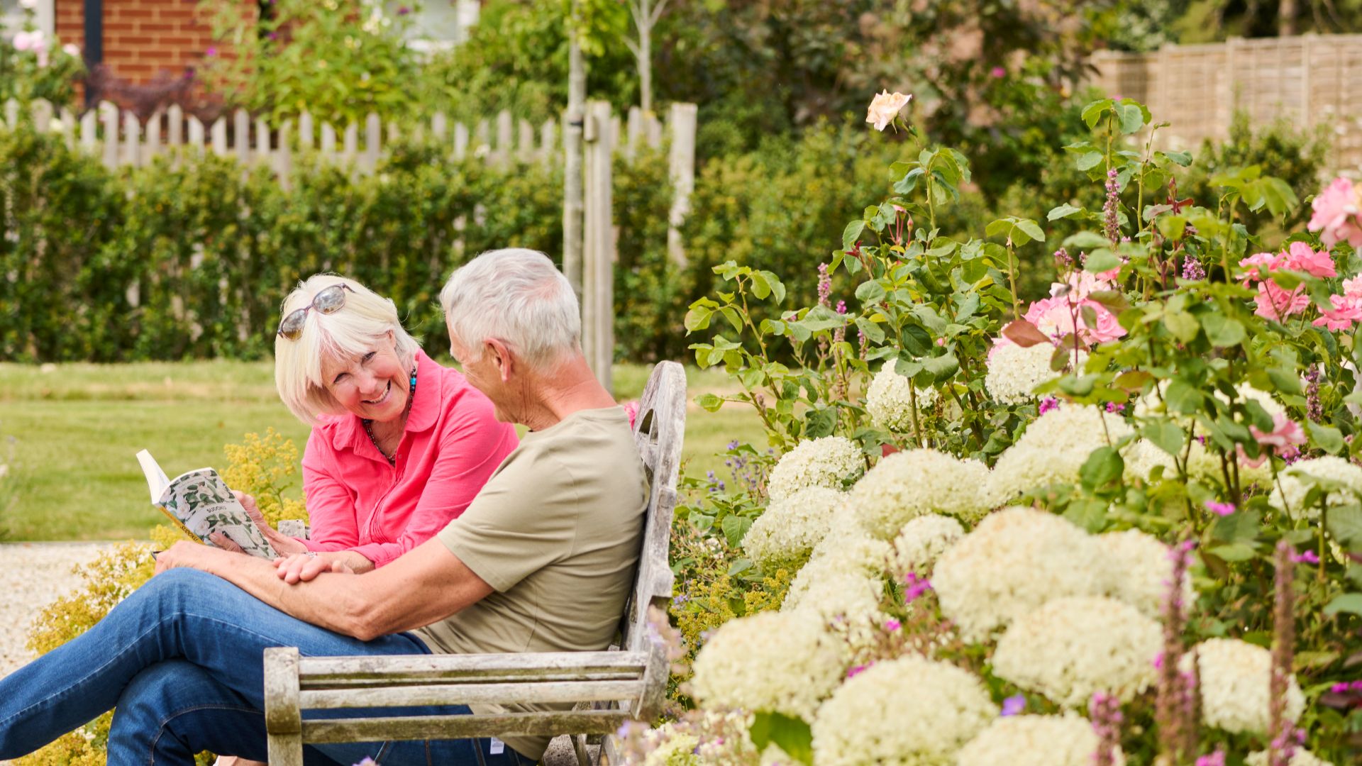 A man and a woman on a balcony drinking a pot of tea. 