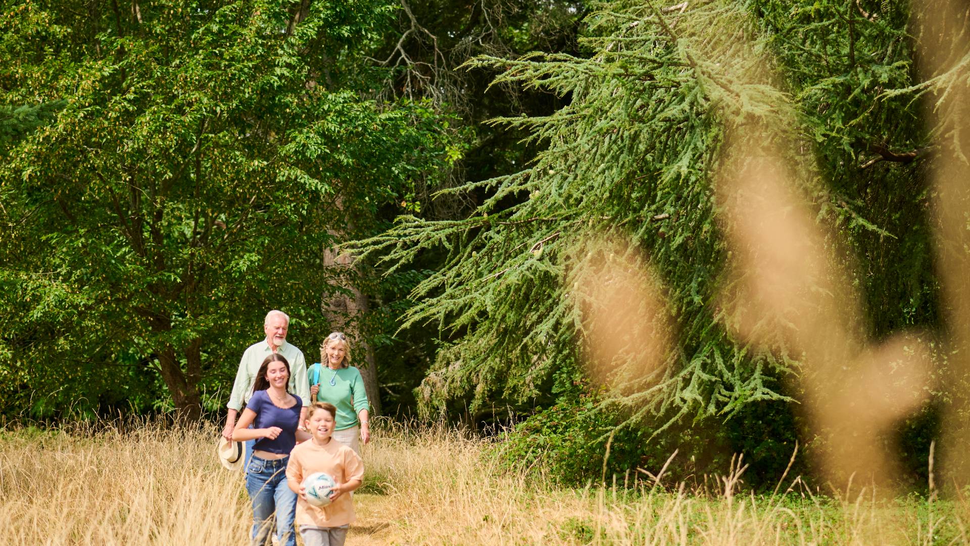 Older adults walking with family through landscaped grounds and enjoying time outdoors together