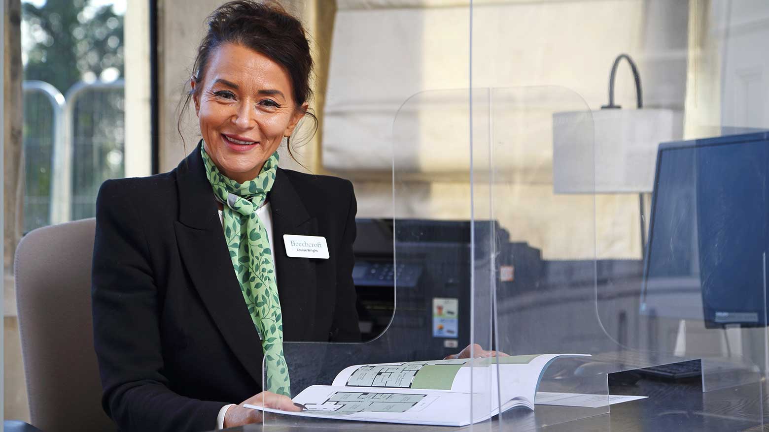 A Beechcroft Developments sales manager sitting behind a desk.