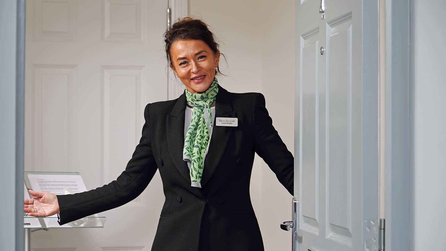 A Beechcroft Developments sales manager opening the front door with a smile.