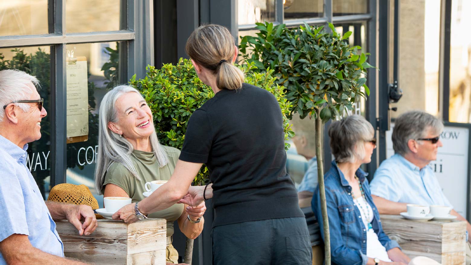 A couple being served coffee at a cafe