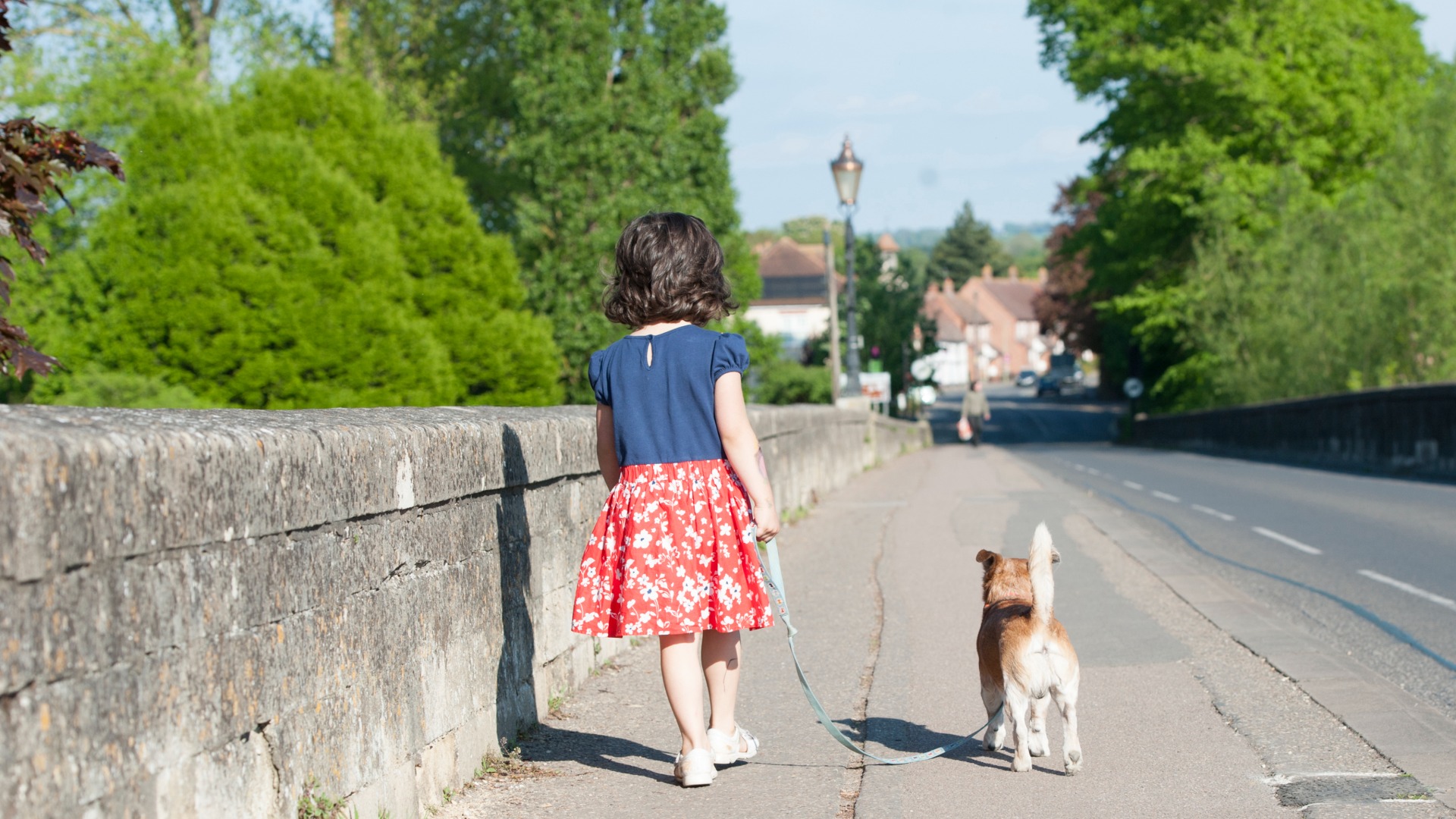 A girl walking a small dog over Wallingford bridge