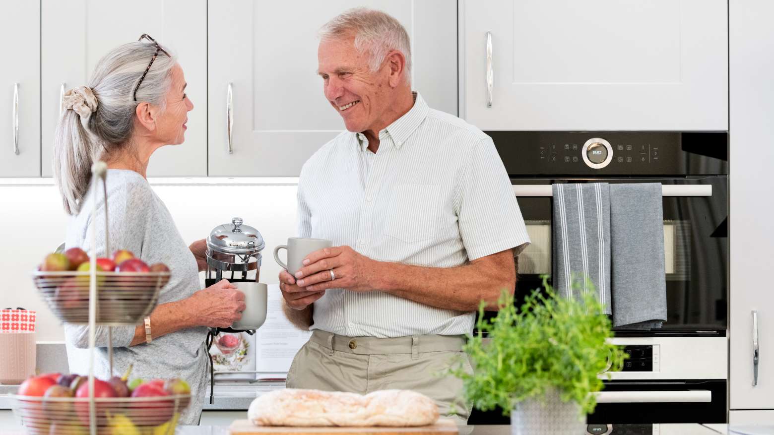 A husband and wife together in their kitchen.