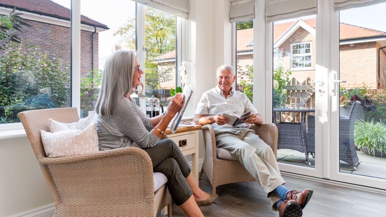 An older couple sat in their conservatory.