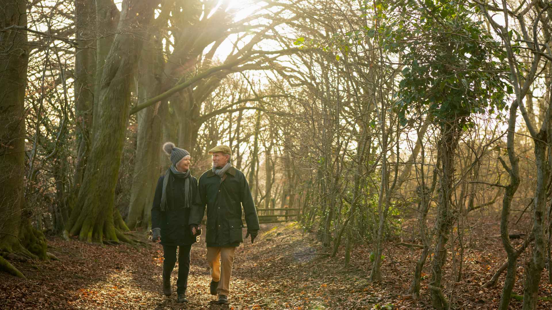 A couple walking through a woodland in the winter