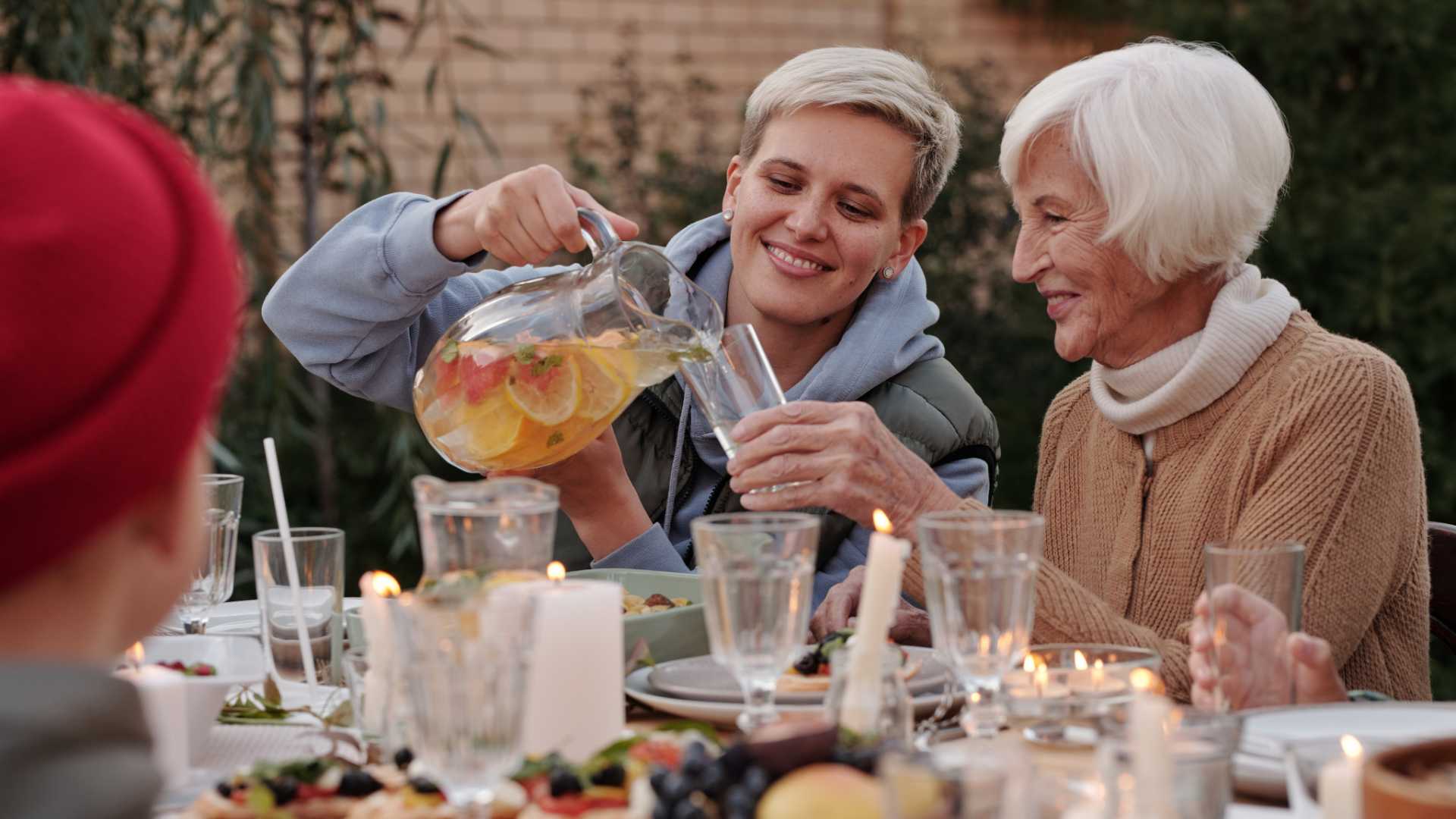 A lady pouring a glass for another woman. 