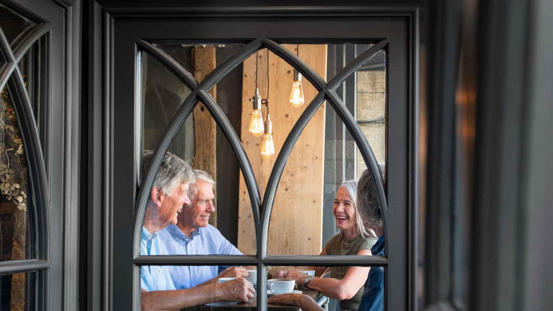 Four people having coffees in a café in Burford, Oxfordshire 