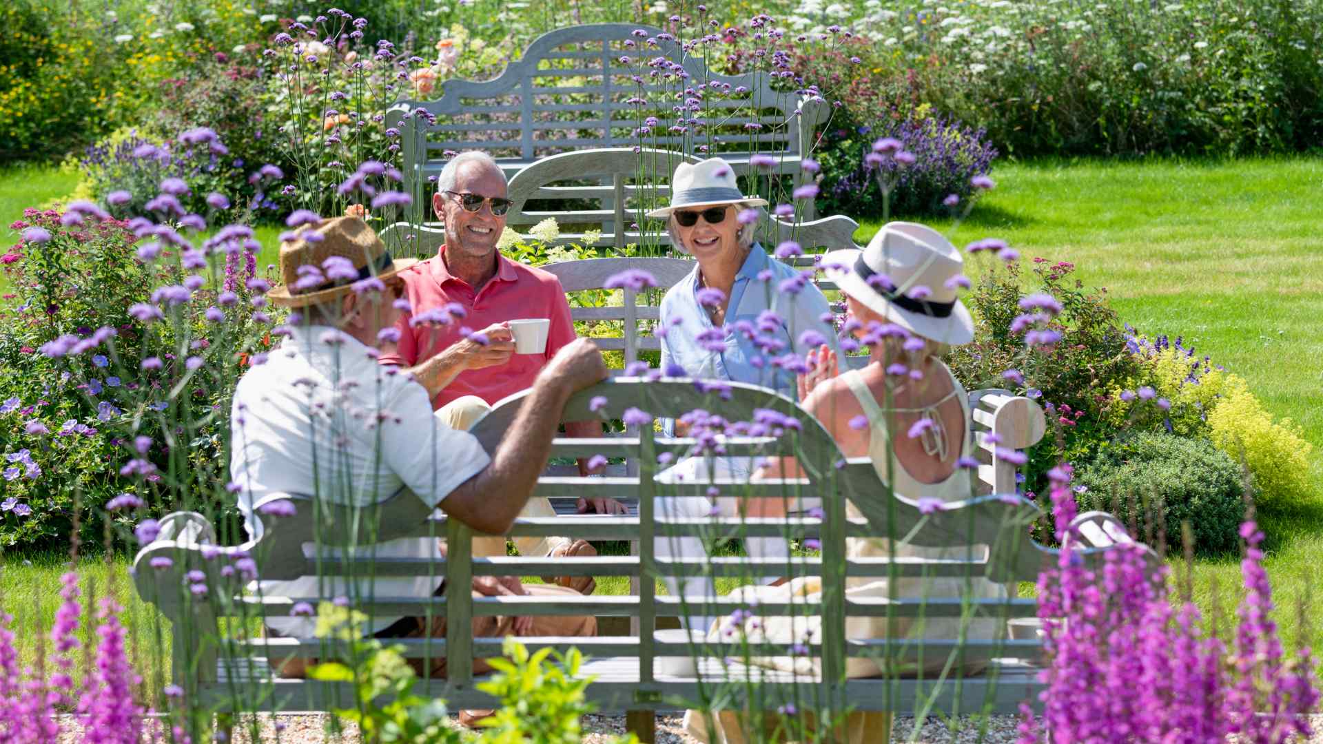 Four people sat in blooming gardens