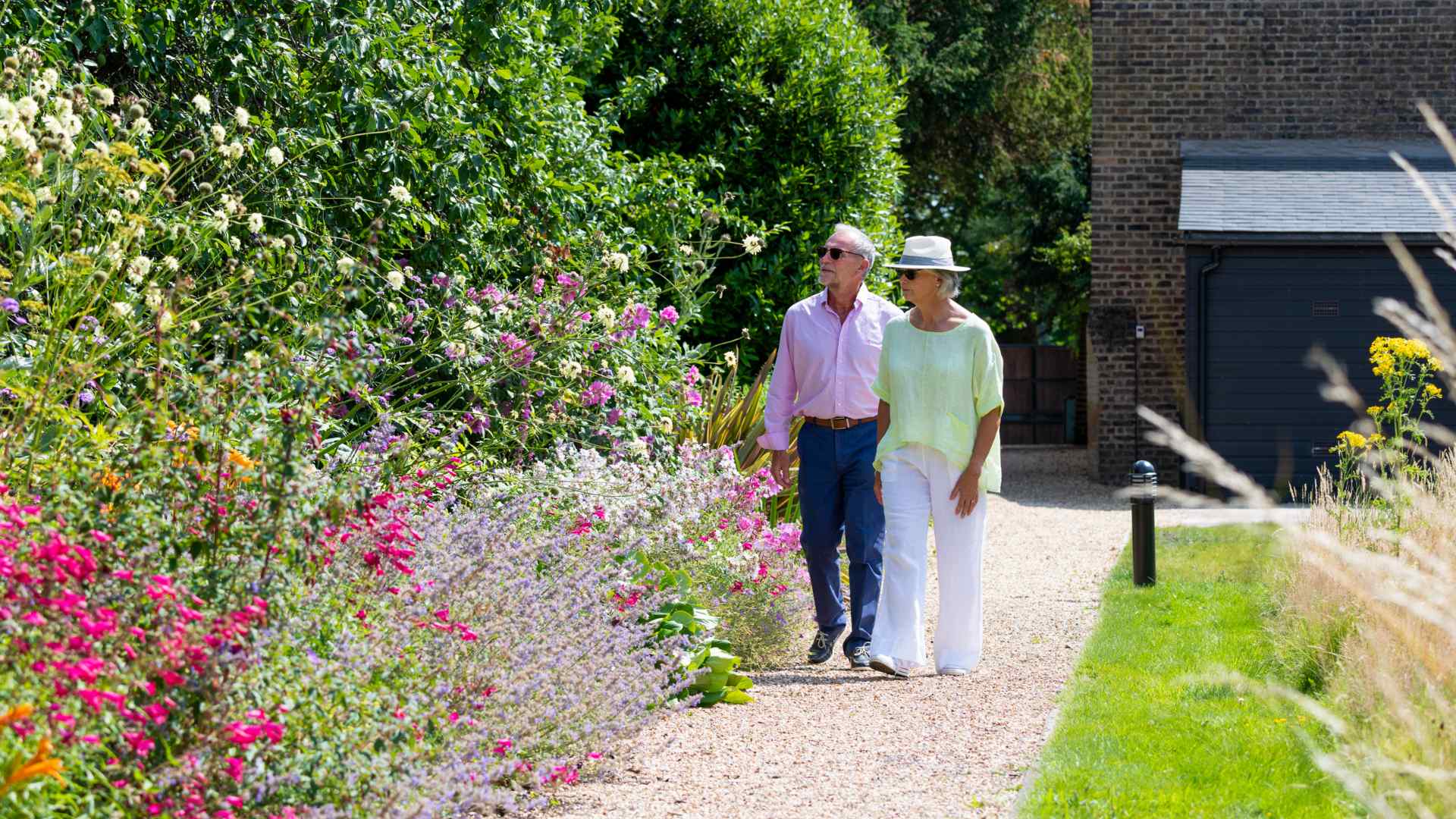 Two people walking through a garden