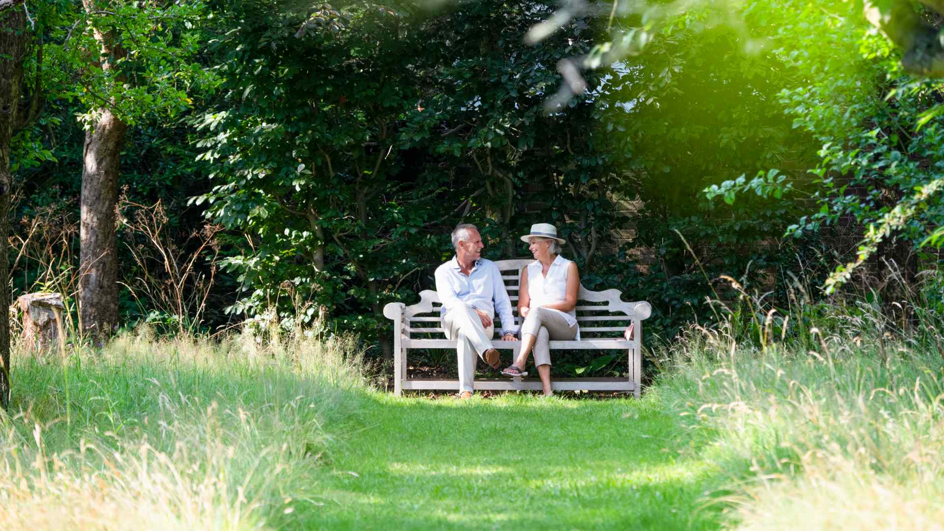 A couple sat on a bench in a park