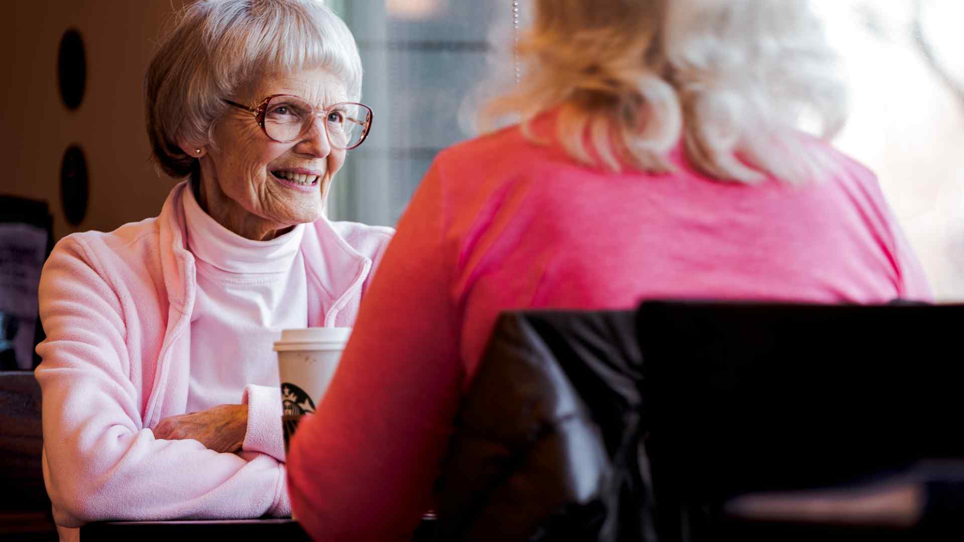An older lady enjoying coffee with a friend 