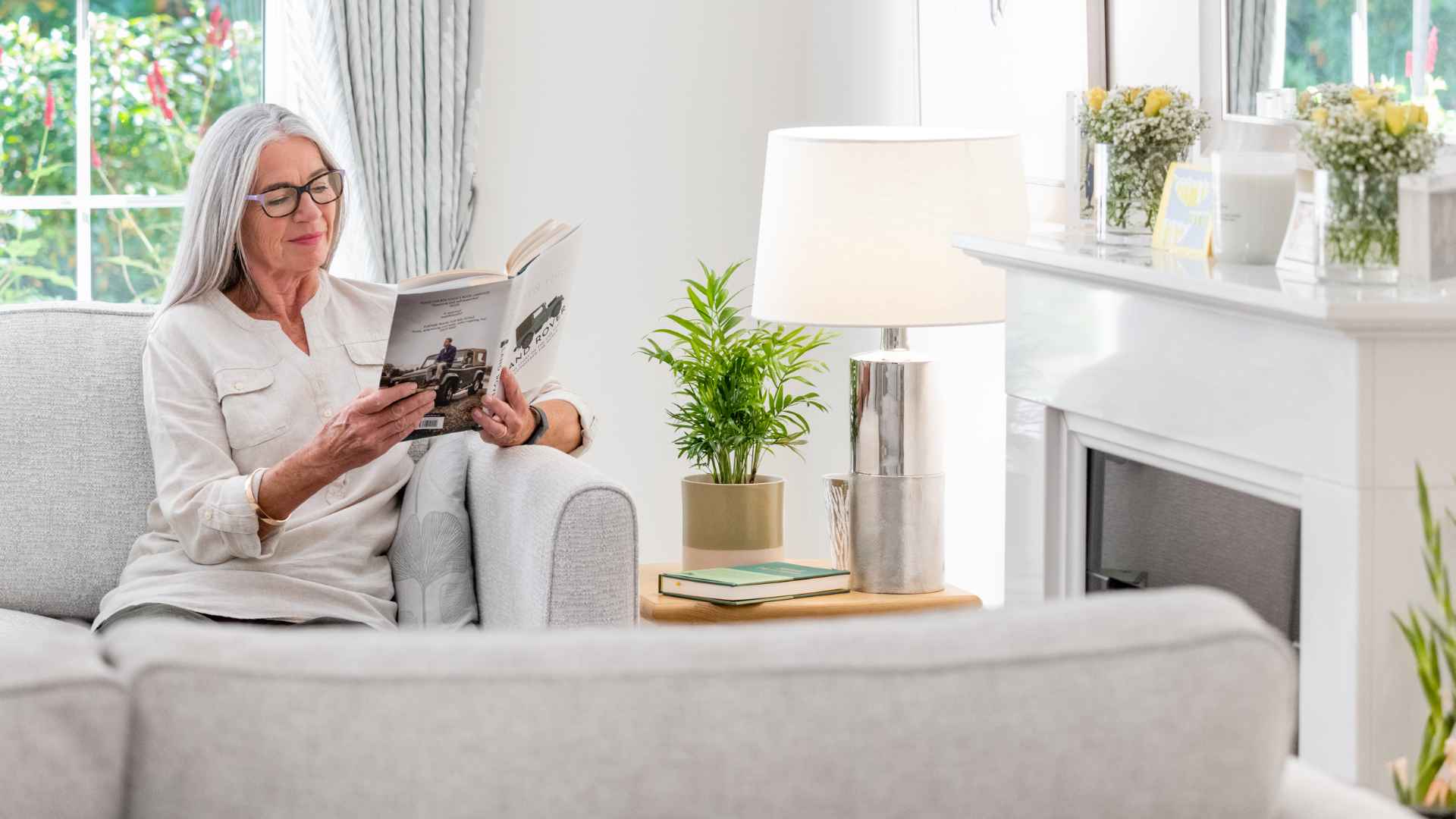 A woman reading a book in her living room