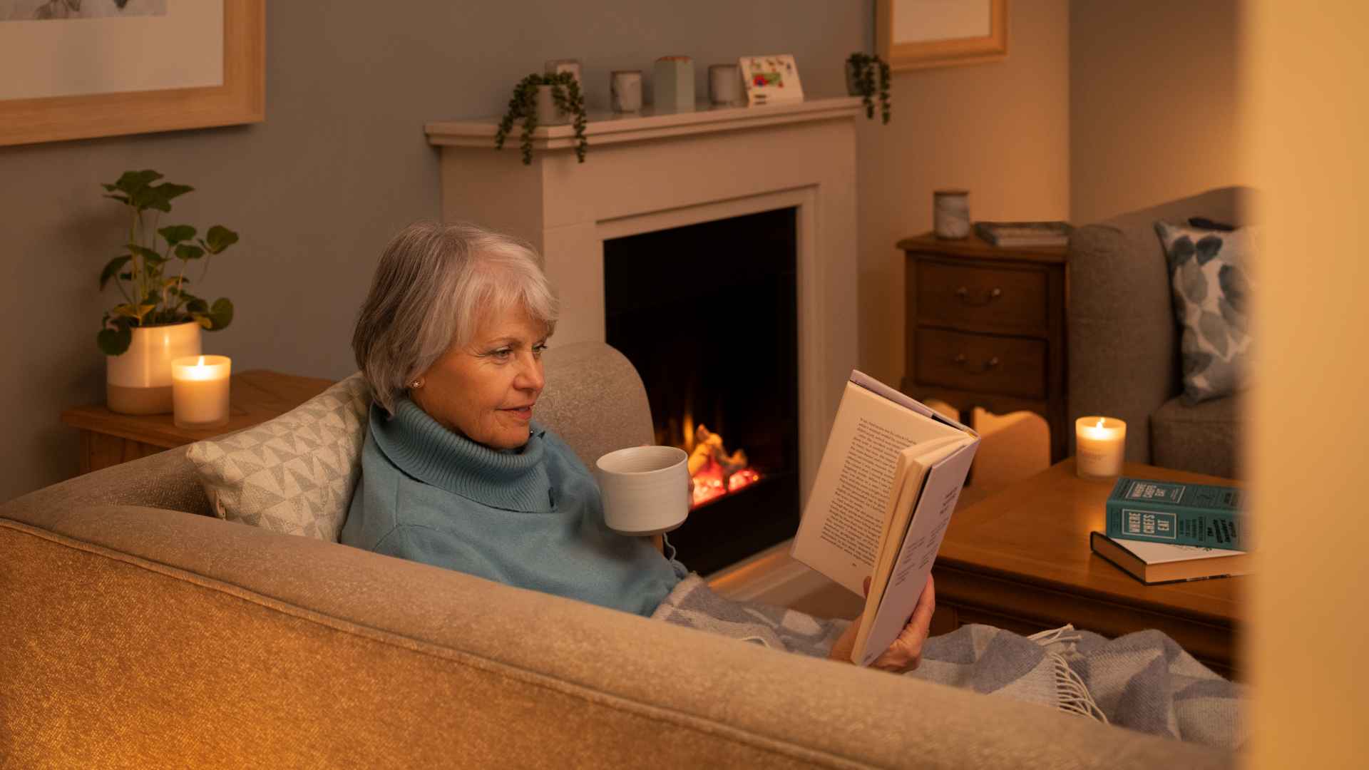 A lady reading a book in her living room