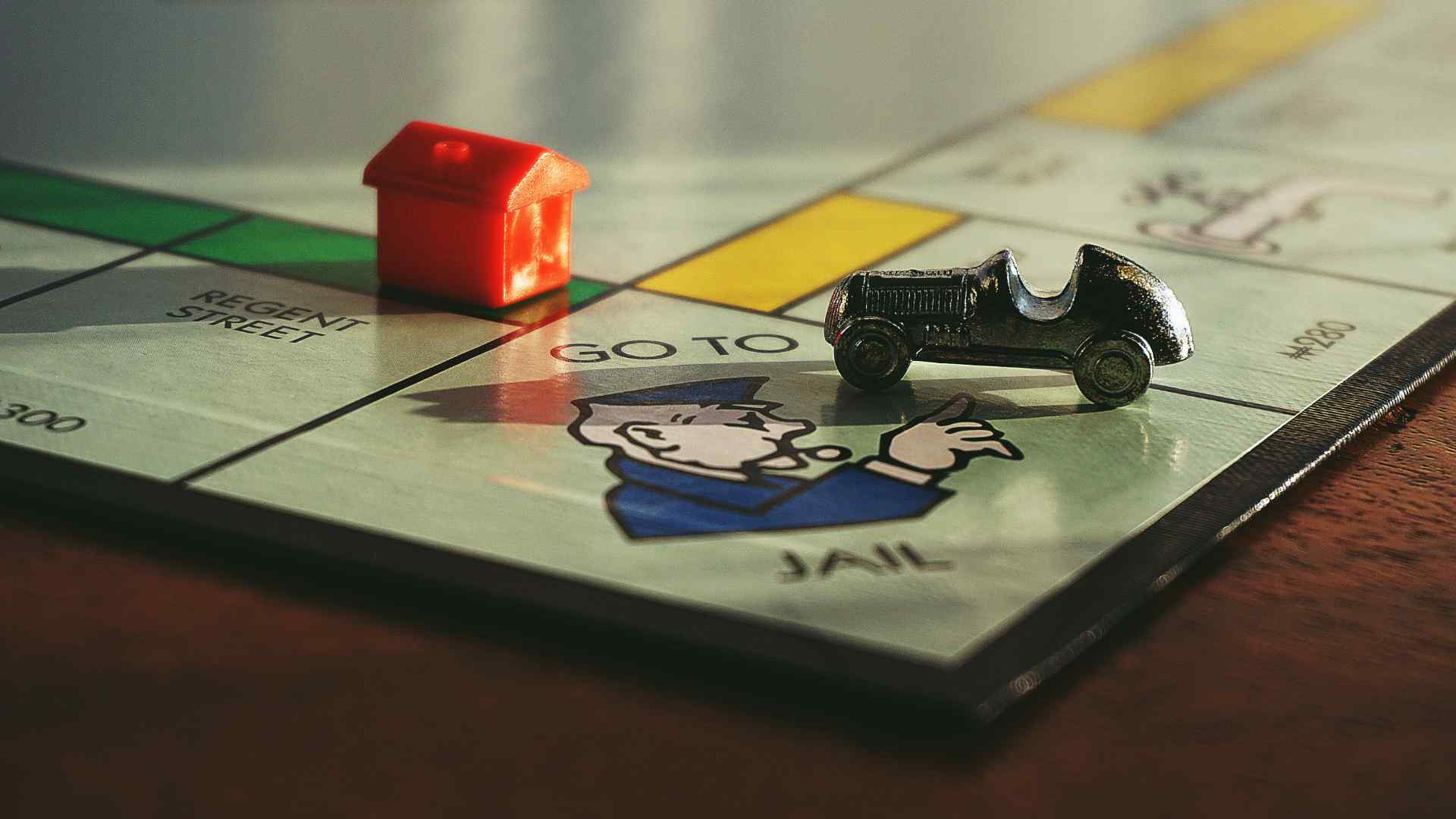 A monopoly board with a hotel and a car