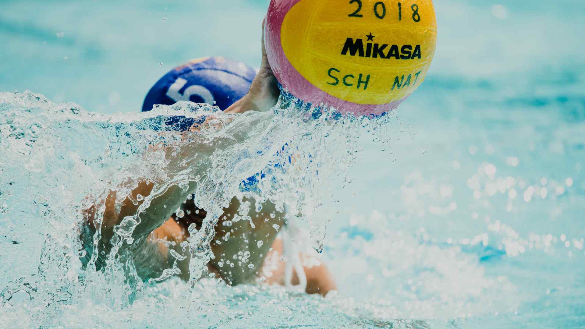 Someone throwing a water polo ball