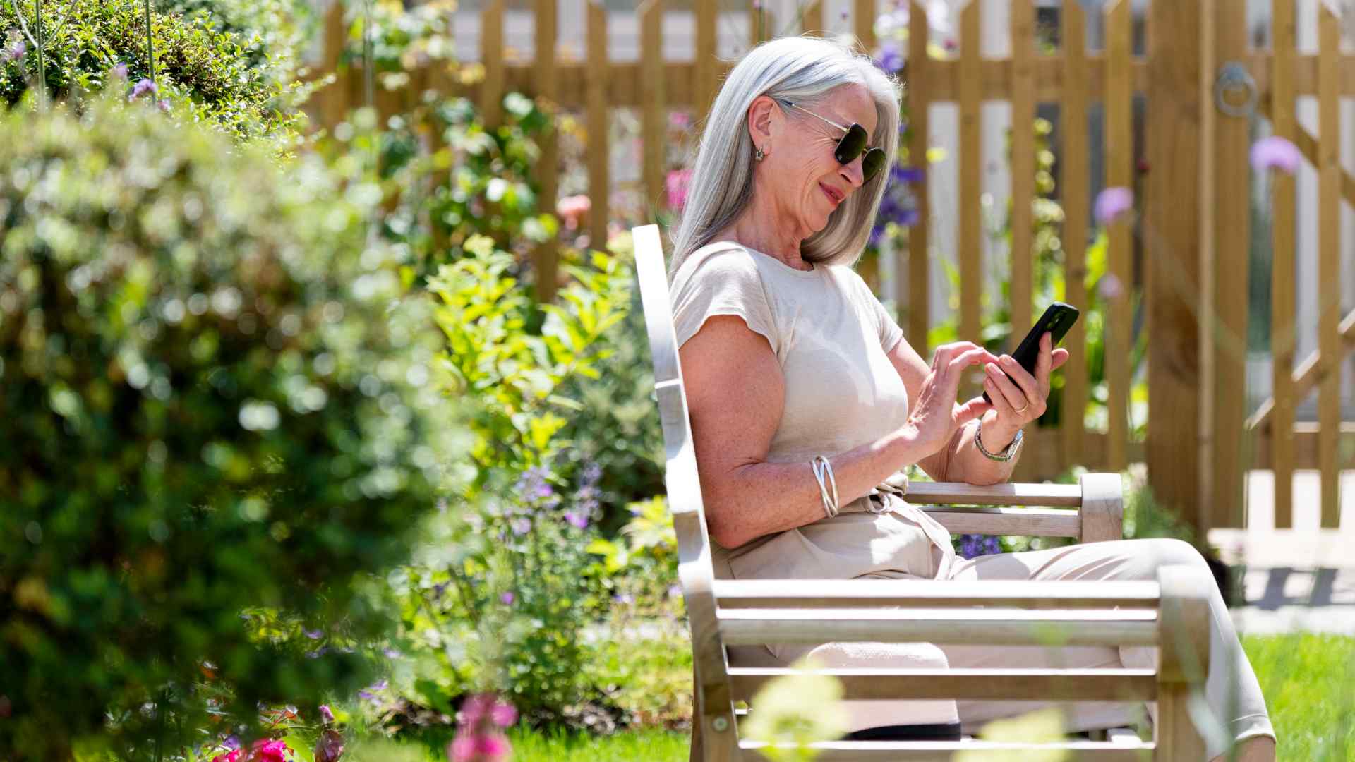 A lady sitting on a bench on her mobile phone