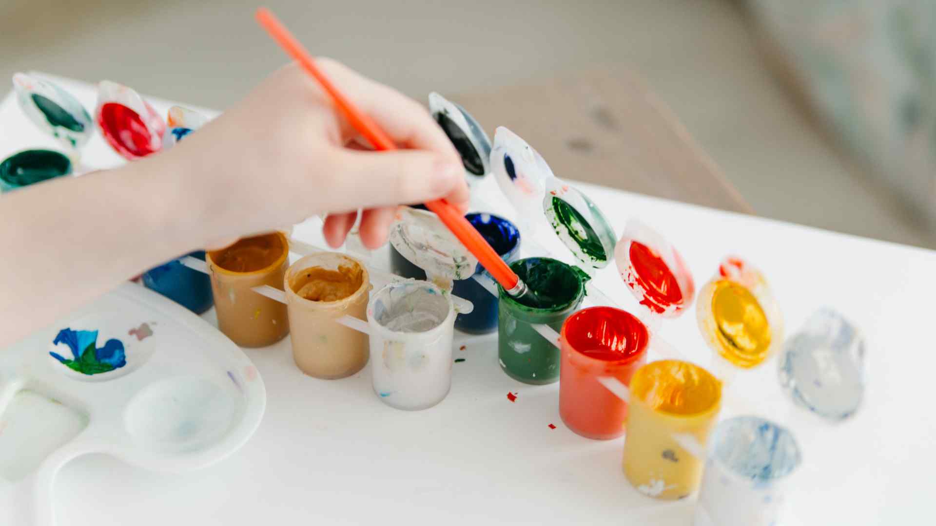 A child using a multi-coloured paint pot