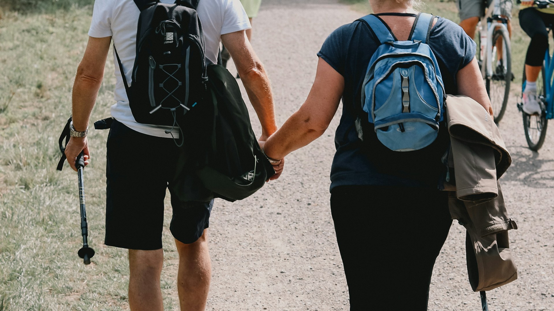 Older couple walking together on a countryside trail during an active holiday